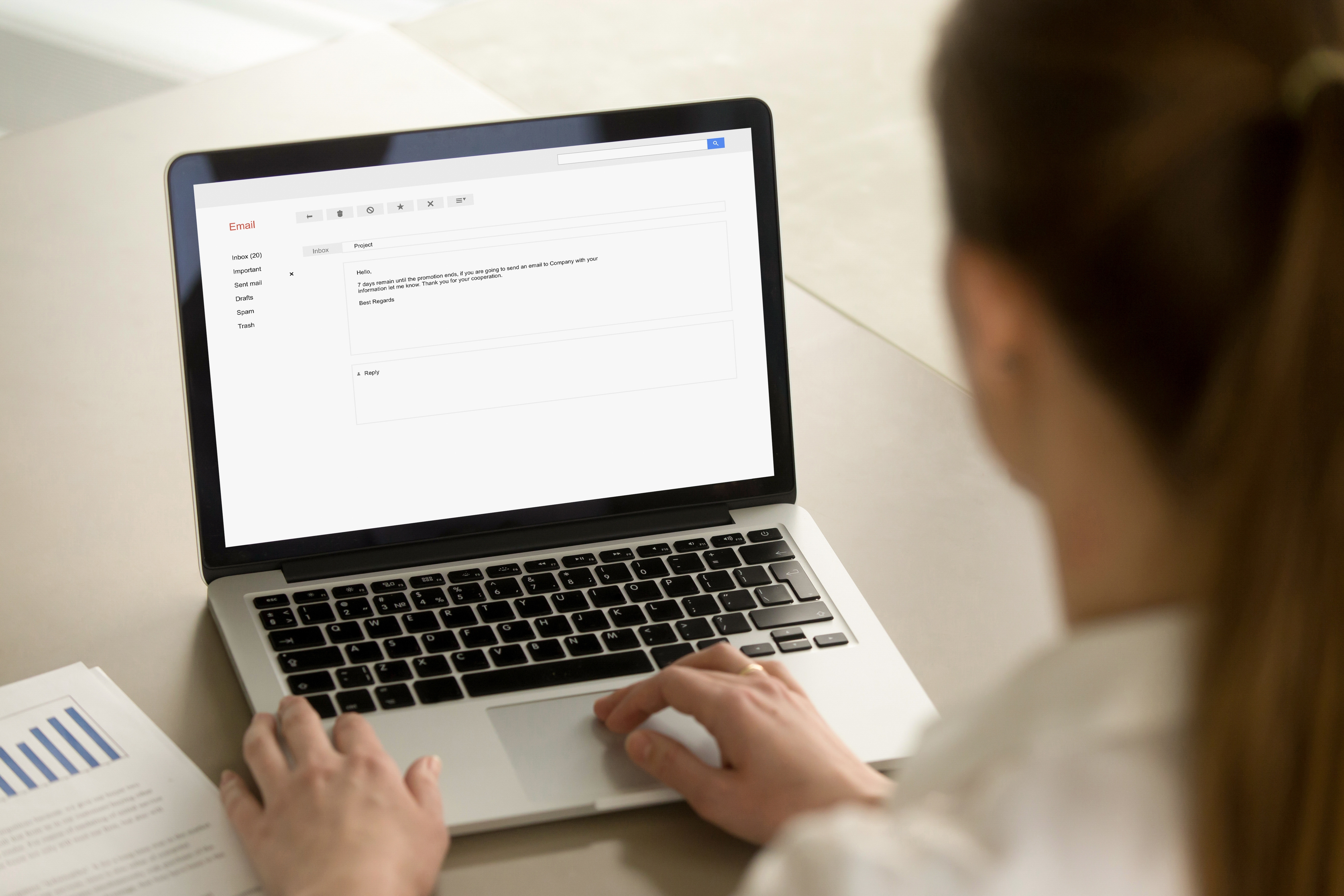 Person typing on laptop with email composition screen open showing draft message.
